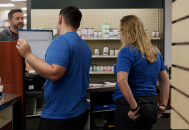 Customer waiting while pharmacy staff complete a prescription pickup
